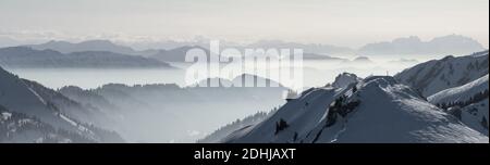 Snow Mountains Panorama im tief liegenden Inversionsnebel. Silhouetten von Nebelbergen. Landschaftlich schöne verschneite Winterlandschaft. Blick von Stuiben nach Saentis Stockfoto