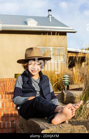 Portrait des Jungen trägt Fedora Hut entspannen auf seine Veranda Stockfoto