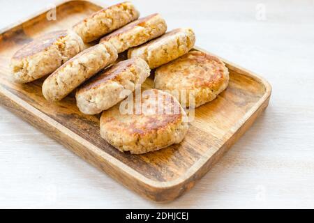 Hausgemachte Hüttenkäse Pfannkuchen syrniki Reihe auf Holztablett auf Weißer Tabellenhintergrund Stockfoto