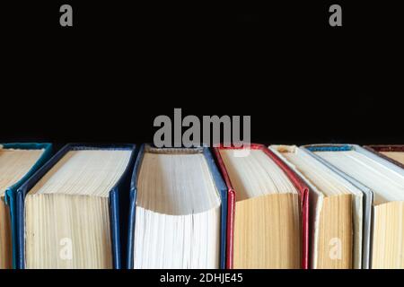 Der Stapel der Bücher ruht auf Regiment close-up.Books with Farbige Abdeckung auf schwarzem Hintergrund Stockfoto