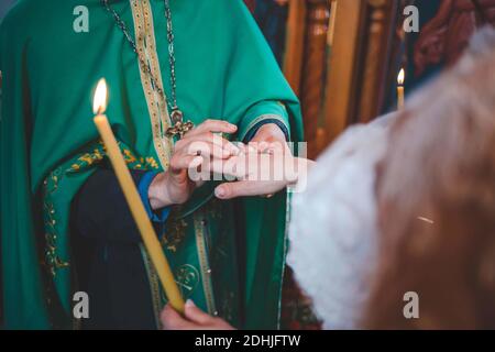 Eine Nahaufnahme des Priesters, der die Hand der Braut hält und Segnen Sie es während einer ehelichen Zeremonie Stockfoto