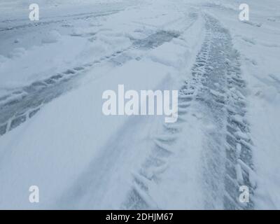 Autoreifen Spuren auf einer verschneiten Straße im Winter. Stockfoto