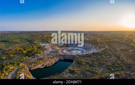 Die Gewinnung der Mineralien mit Hilfe der speziellen Ausrüstung in der Nähe des kleinen Sees im warmen Abendlicht in der malerischen Ukraine. Antenne Panorama Drohne s Stockfoto