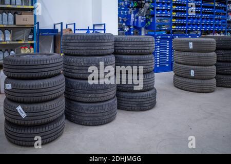 In einer Autowerkstatt gibt es viele gestapelte Autoreifen Stockfoto