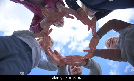 Eine freundliche Familie macht aus ihren Händen einen Kreis Gegen den blauen Himmel Stockfoto