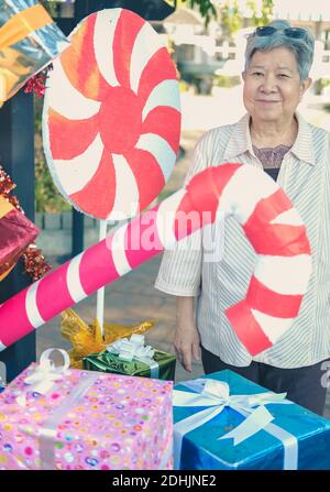 asiatische alte ältere Frau ältere ältere Frau mit dekorativen Geschenk Geschenkschachtel zu weihnachten Stockfoto