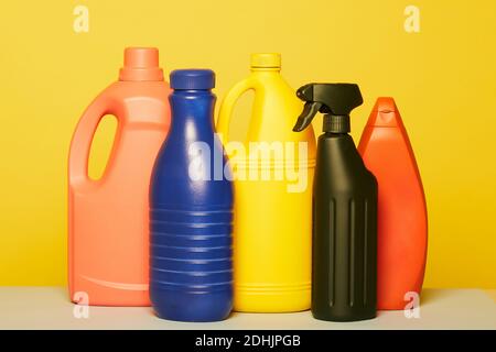 Set von bunten verschiedenen Kunststoffbehältern aus Flüssigwaschmittel platziert In Reihe auf gelbem Hintergrund im Studio Stockfoto