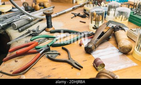 Set von verschiedenen professionellen Instrumenten und Werkzeugen auf Shabby platziert Holztisch in Juwelierwerkstatt Stockfoto