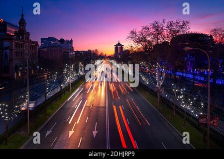 Tolle Aussicht auf rote und weiße Ampelpfade Straße in Madrid unter Sonnenuntergang Himmel Stockfoto
