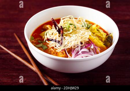 Thailändisches Gericht von Khao soi in einer weißen Schüssel auf Eine dunkle Tabelle mit Kopierplatz Stockfoto
