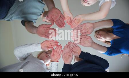 Eine freundliche Großfamilie macht aus den Handflächen einen Kreis. Stockfoto