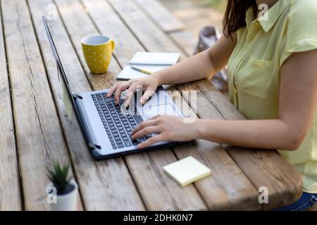 Junge Frau mit Laptop-Computer im öffentlichen Park - Millennial freiberufliche Mitarbeiterin, die ferngesteuert hinter einem Laptop in der Nähe arbeitet Ein Stadtpark - Technol Stockfoto