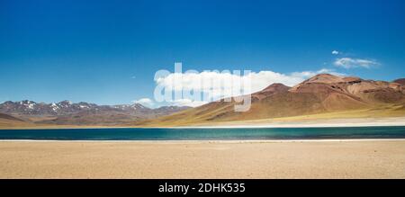 Der Vulkan Miniques erhebt sich über dem hellblauen Wasser der Laguna Miscanti San Pedro de Atacama, Andes, Chile Stockfoto