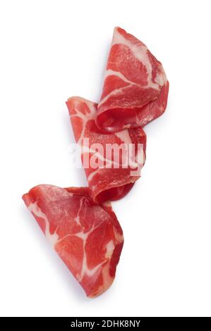 Studioaufnahme von Coppa, einem italienischen trocken gehäuteten Schweinefleisch, vor weißem Hintergrund geschnitten - John Gollop Stockfoto