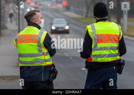 11. Dezember 2020, Sachsen, Görlitz: Zwei Polizisten der Bundespolizei stehen auf der Straße und beobachten den Verkehr aus Polen. Polizeibeamte der Bundespolizei und des Polizeireviers Görlitz führten gemeinsam eine Kontrolle über die Coronaschutzverordnung auf der Stadtbrücke Görlitz durch. Die Gesamtzahl der Coronainfektionen in Sachsen hat die Marke von 80,000 überschritten. Besonders betroffen ist der Landkreis Görlitz. Foto: Daniel Schäfer/dpa-Zentralbild/dpa Stockfoto