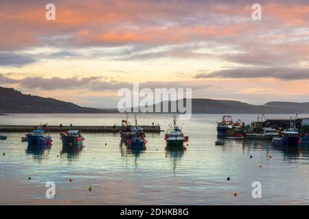 Lyme Regis, Dorset, Großbritannien. Dezember 2020. Wetter in Großbritannien. Die Wolken leuchten orange bei Sonnenuntergang über dem historischen Cobb Harbour bei Lyme Regis in Dorset. Bild: Graham Hunt/Alamy Live News Stockfoto