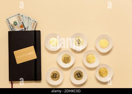 Geschäftskonzept-Artikel auf dem Tisch Goldbitcoins, Dollar, Tagebuch, Goldkarte, auf beigem Hintergrund. Bitcoins sind eine digitale Währung, die globale Marke Stockfoto