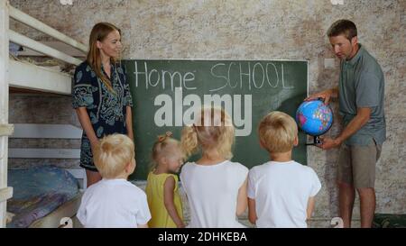 Home School-Konzept. Eltern lehren ihre Kinder mit einem Globus in der Hand. Stockfoto