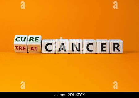 Heilung oder Behandlung Krebs Symbol. Wurde ein Würfel gedreht und ändert die Worte „Treat Cancer“ in „Cure Cancer“. Schöner orangefarbener Hintergrund. Medizinisch und Heilung oder Behandlung c Stockfoto