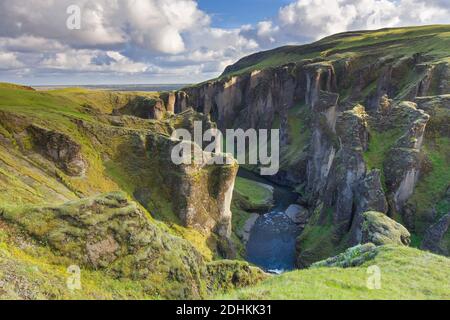 Der Fluss Fjaðrá fließt durch die Schlucht Fjaðrárgljúfur / Fjädrargljufur bei Kirkjubæjarklaustur im Sommer, Island Stockfoto