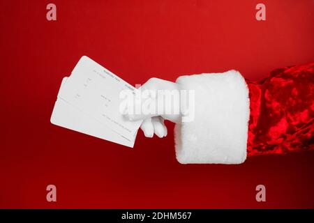 Santa mit Flugschein auf rotem Hintergrund. Das Reisekonzept für das neue Jahr. Verkaufstickets Stockfoto