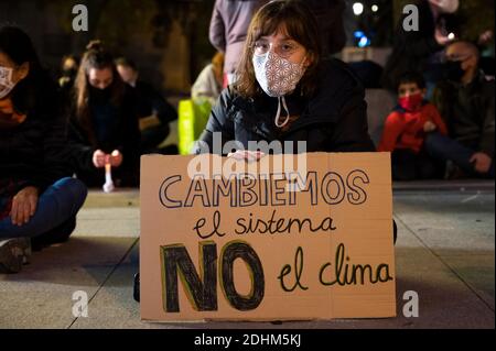 Madrid, Spanien. Dezember 2020. Klimaaktivistin mit einem Plakat mit der Aufschrift "Let's change the System, not the Climate" während eines Protestes vor dem spanischen Parlament, der zum Handeln aufruft, seit es fünf Jahre nach dem Pariser Klimaabkommen ist und die globale Temperatur steigt. Quelle: Marcos del Mazo/Alamy Live News Stockfoto