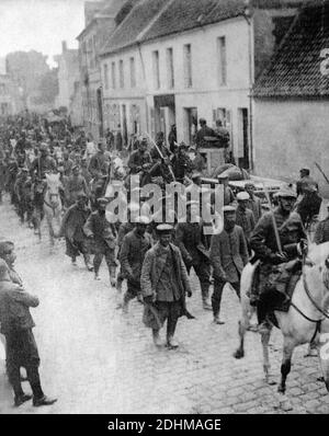 Ein historisches Foto einer Gruppe von 250 deutschen Prisonern, die von Französisch cavarly durch Aubigny, Aubigny-en-Artois, Pas-de-Calais, Frankreich, begleitet wurden, aufgenommen aus einer Postkarte um 1914-1916. Stockfoto