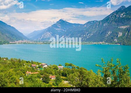 Schöner Blick über den Idrosee Italien. Häuser, ein kleines Dorf auf der Vorder- und blaues Wasser und Berge im Hintergrund. Stockfoto