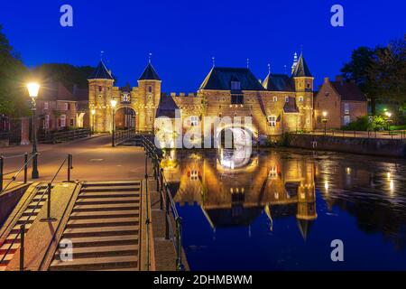 Best of Amersfoort, altes Stadttor Koppelpoort in Amersfoort Stadt während der Dämmerung. Zwei Türme sind mit einem Bogentor verbunden. Stockfoto