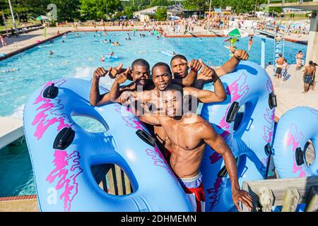 Alabama Decatur Point Mallard Park Wasserpark, Wasserrutsche Schwimmbad, Schwarze Teenager Teenager Teenager Teenager Jungen Freunde innertubes schwimmt, Stockfoto