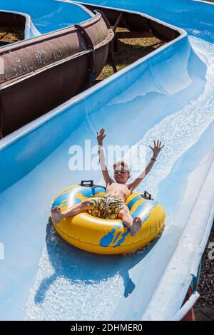 Alabama Decatur Point Mallard Park Waterpark, Wasserrutsche Junge, der mit dem Innenrohr nach unten reitet, Stockfoto