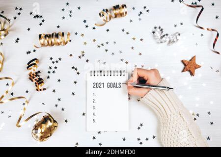 Feiertagsdekorationen und Notizbuch mit 2021 Toren auf weißem rustikalem Tisch, flacher Lay-Stil. Weihnachtskonzept. Stockfoto