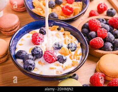 Müsli mit Beeren und Milch. Leckeres, gesundes Frühstück. Flocken und süßes Gebäck. Hochwertige Fotos Stockfoto