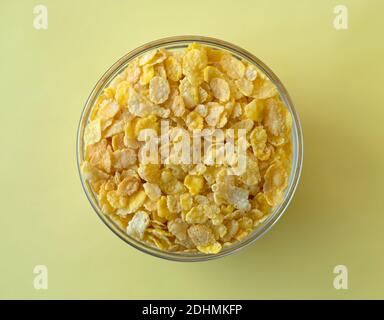 Schüssel mit Getreideflocken auf gelbem Hintergrund. Flache Lay-Optik Stockfoto