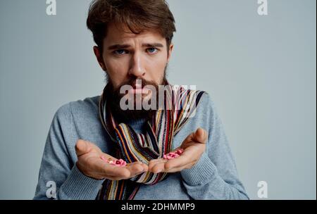 Bärtiger Mann in einem Schal mit Pillen in den Händen Gesundheitsprobleme Medizin Stockfoto