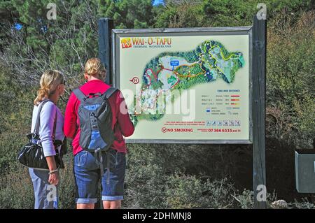 Paar auf der Suche auf Karte von Wai-O-Tapu Thermal Wonderland, Rotorua, Bucht von viel Region, Nordinsel, Neuseeland Stockfoto