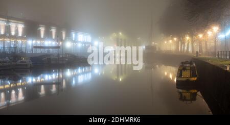 Boote und Lagerhäuser sind in einer Herbstnacht am Hafen von Bristol in Nebel gehüllt. Stockfoto