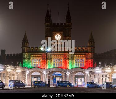 Taxis warten vor dem Haupteingang zum Bahnhof Temple Meads in Bristol, der nachts rot beleuchtet ist. Stockfoto