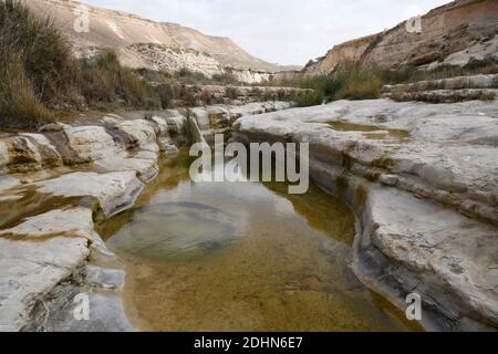 Wadi Hawarim, Negev-Wüste, Israel. Hochwasser sammelt sich in den Steinbecken. Stockfoto