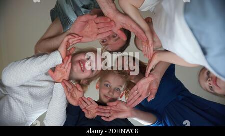 Eine freundliche Familie macht aus ihren Händen einen Kreis. Stockfoto