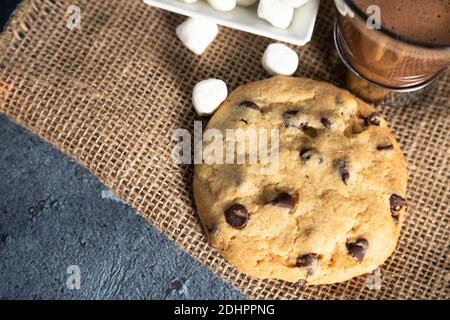 Chocolate Chip Cookie mit bestreuten Marshmallows und einer Tasse Heiße Schokolade Stockfoto