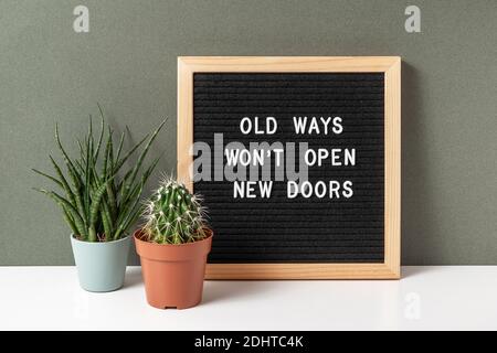 Alte Wege öffnen keine neuen Türen. Motivationszitat auf Briefbrett, Kaktus, saftige Blume auf weißem Tisch. Konzept inspirierendes Zitat des Tages. Fr. Stockfoto