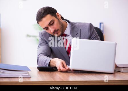 Männlicher Mitarbeiter, der Flash-Laufwerk in den Laptop einsteckt Stockfoto