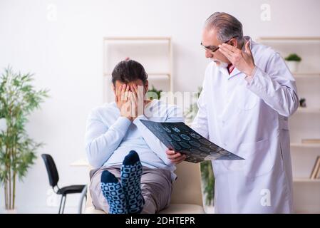 Kranker Mann besucht alten Arzt Radiologen Stockfoto