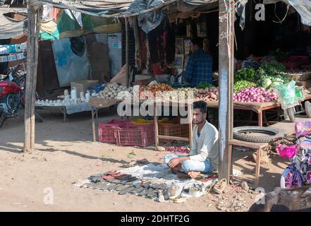 Verkauf von Obst und Reparatur von Schuhen auf der Straße von Shahpura, Madhya Pradesh, Indien. Stockfoto
