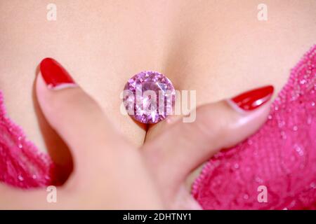 Lege den lila Amethyst-Diamanten in die Mitte der Brust der Frau. Stockfoto