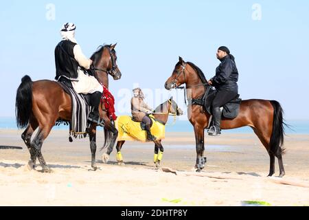 Jahra Governorate, Kuwait. Dezember 2020. Menschen reiten auf Pferden während einer Reitshow in Jahra Governorate, Kuwait, 11. Dezember 2020. Kuwaitische arabische Pferdebesitzer veranstalteten am Freitag in der Wüste von Jahra Governorate von Kuwait eine Reitshow, um die arabische Reittradition vorzustellen. Kredit: Ghazy Qaffaf/Xinhua/Alamy Live Nachrichten Stockfoto