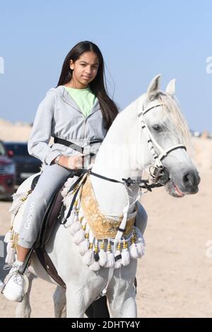 Jahra Governorate, Kuwait. Dezember 2020. Ein Kind reitet auf einem Pferd während einer Reitshow in Jahra Governorate, Kuwait, 11. Dezember 2020. Kuwaitische arabische Pferdebesitzer veranstalteten am Freitag in der Wüste von Jahra Governorate von Kuwait eine Reitshow, um die arabische Reittradition vorzustellen. Kredit: Ghazy Qaffaf/Xinhua/Alamy Live Nachrichten Stockfoto