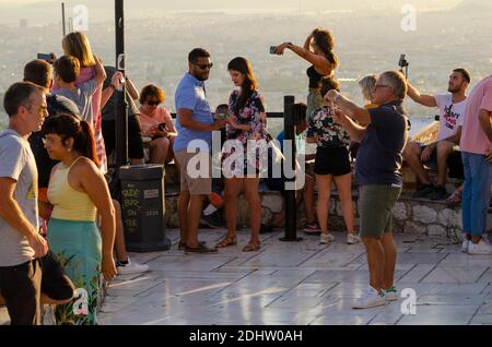 Touristen machen Schnappschüsse auf ihren Smartphones am Aussichtspunkt auf dem Lycabettus-Hügel im Zentrum Athens Griechenland - Foto: Geopix Stockfoto