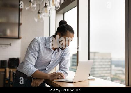 Serious biracial Mann Arbeit am Computer am Arbeitsplatz Stockfoto